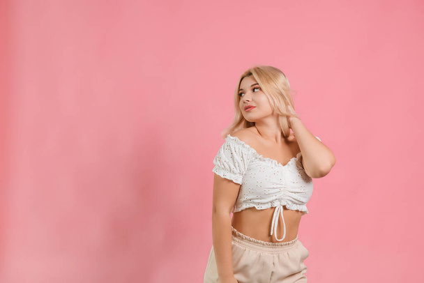 a girl in white clothes on a pink background poses with different emotions - Valokuva, kuva