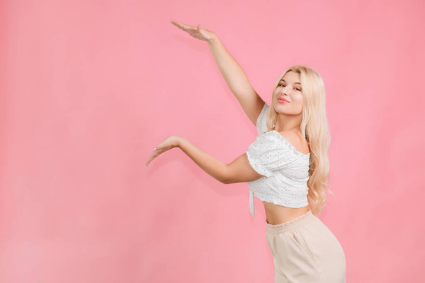 very beautiful young girl posing with emotions on a pink background - Foto, afbeelding