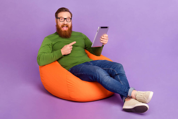 Full body portrait of astonished crazy person direct finger tablet isolated on purple color background. - Foto, Imagem