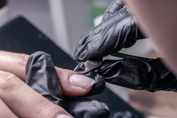 The process of manicure in a beauty salon close-up. Cuticle removal - Fotoğraf, Görsel