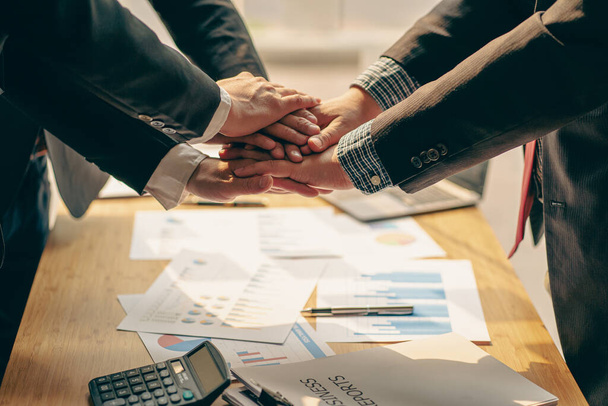 a group of business people shaking hands in the creative office, a young team coordinates and shakes hands, cooperation, teamwork concept - Photo, Image