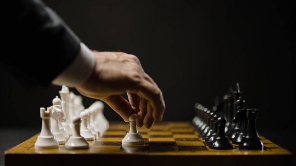 Man moving white chess piece, starting game, concept of business start, rivalry - Φωτογραφία, εικόνα