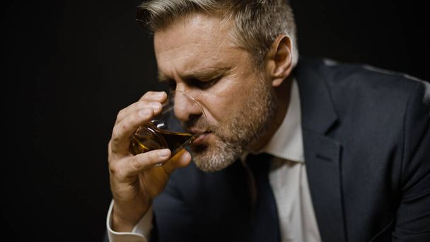 Businessman drinking whiskey, feeling lonely, problems in life and business - 写真・画像