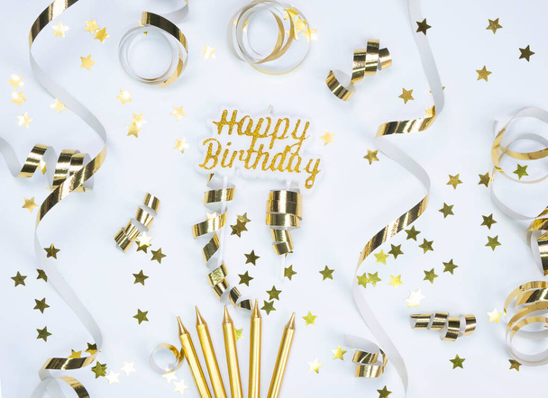 Hintergrund mit goldenen Sternen, Serpentinen und Kerzen, Konzept zur Feier eines Geburtstages, Jubiläums oder einer Party in Goldtönen - Foto, Bild
