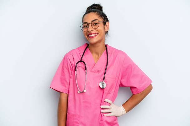 hispanic  woman smiling happily with a hand on hip and confident. nurse concept - Photo, image