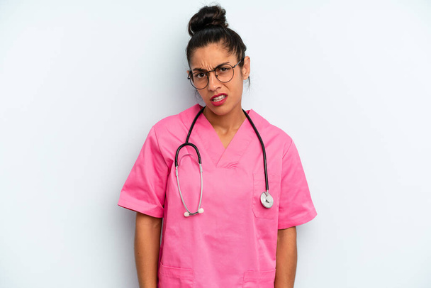 hispanic  woman feeling puzzled and confused. nurse concept - Foto, Bild