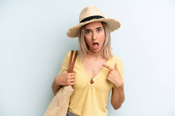 blonde woman looking shocked and surprised with mouth wide open, pointing to self. summer concept - Фото, изображение