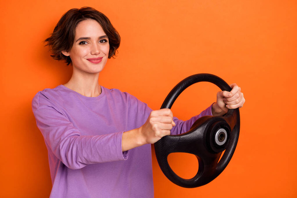 Profile portrait of pretty positive person hold wheel drive new car isolated on orange color background. - Fotó, kép