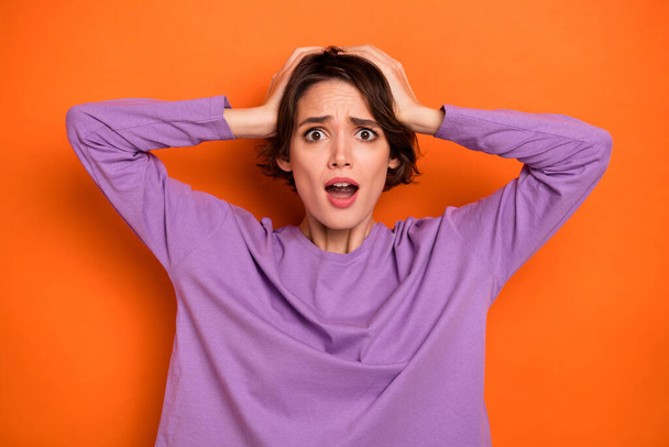 Photo of amazed impressed lady wear violet sweatshirt arms head open mouth isolated orange color background. - Foto, immagini