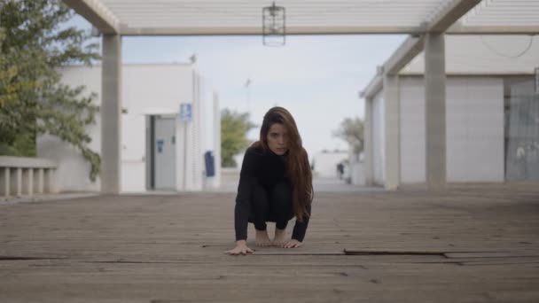 Jonge vrouw op houten brug kijkt in de camera en beweegt als een kat - 4K Horizontale video - Video
