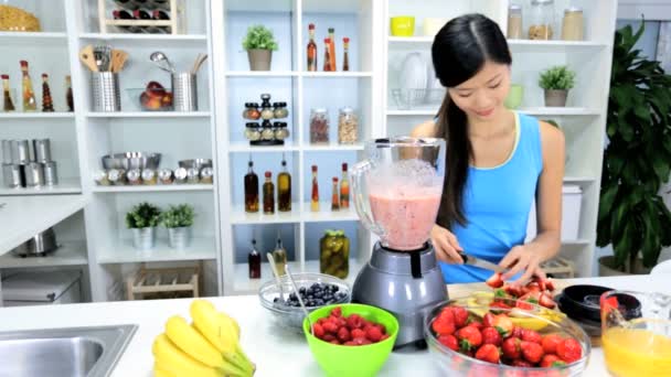 Paar bereitet gesunden hausgemachten Obst-Smoothie zu - Filmmaterial, Video