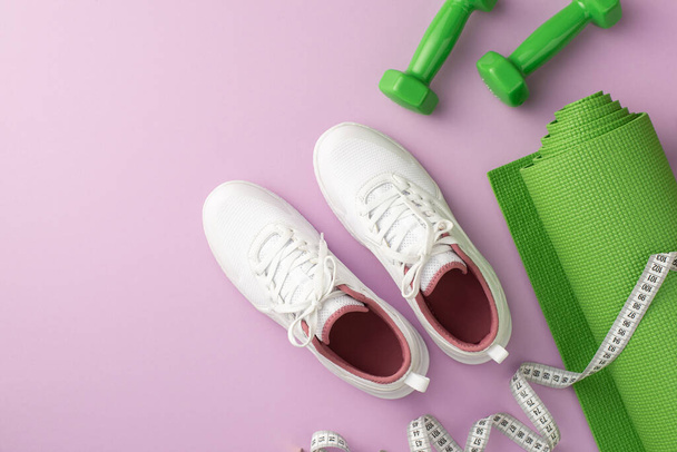 Fitness-Konzept. Foto von oben von grünen Sportmatten Maßhanteln und weißen Sportschuhen auf isoliertem pastelllila Hintergrund - Foto, Bild