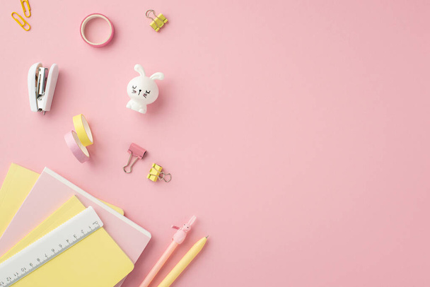 Back to school concept. Top view photo of school accessories copybooks pens ruler stapler binder clips adhesive tape and bunny shaped sharpener on isolated pink background - Foto, Imagem