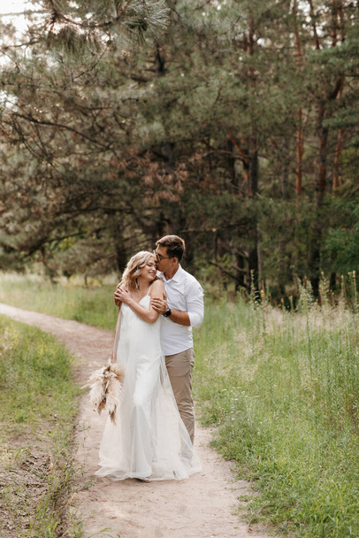 young couple of newlyweds on a walk in a pine forest - Foto, Imagen