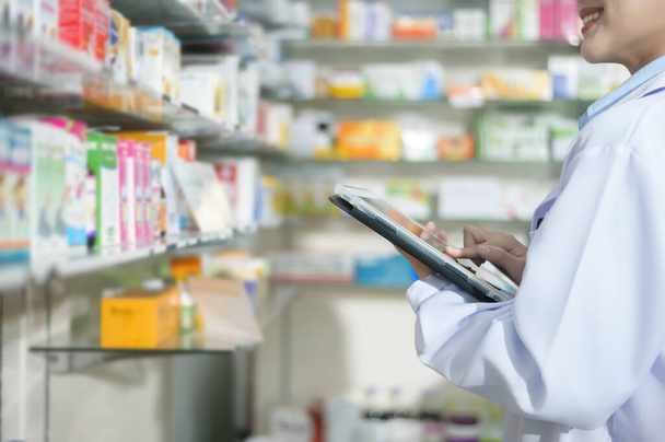 A Portrait of female pharmacist using tablet in a modern pharmacy drugstore. - Foto, Imagem