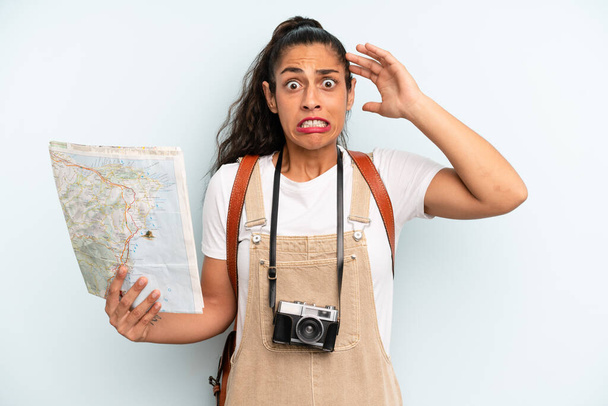 hispanic woman feeling stressed, anxious or scared, with hands on head. tourist with a map - Foto, imagen
