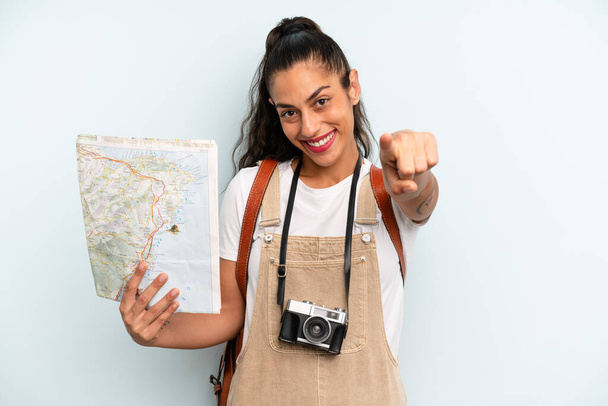 hispanic woman pointing at camera choosing you. tourist with a map - Foto, afbeelding