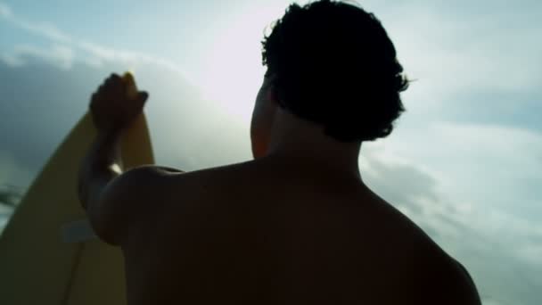 Homem segurando prancha na praia
 - Filmagem, Vídeo