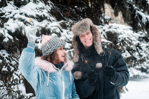 Šťastný pár se baví sněhem. Žena a muž kráčející v zimním lese.  - Fotografie, Obrázek