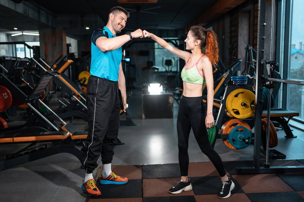 coach greeting woman after training in fitness club - Foto, Imagen