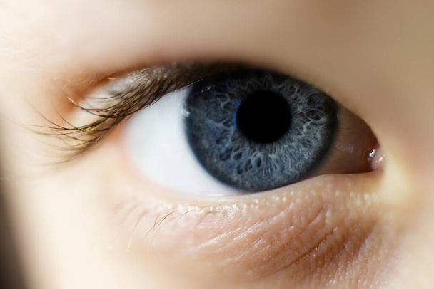 Macro fotografie van kindblauw oog met getextureerde iris. - Foto, afbeelding