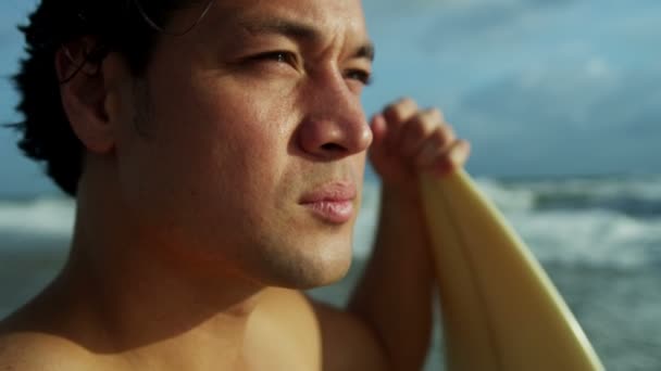 Hombre sosteniendo tabla de surf en la playa
 - Imágenes, Vídeo