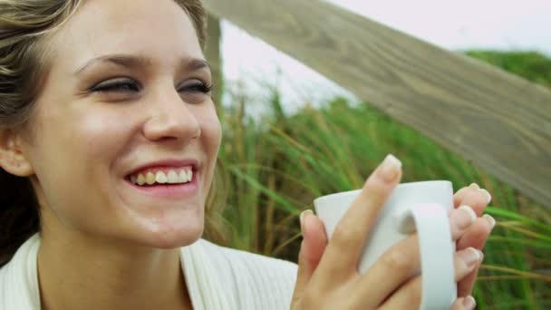 Mädchen am Strand trinkt Kaffee - Filmmaterial, Video