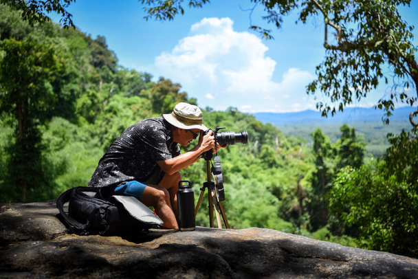 Old man hiking in the mountains and taking photos in Thailand. image have grain and noise, blur and soft focus. - Foto, Imagen