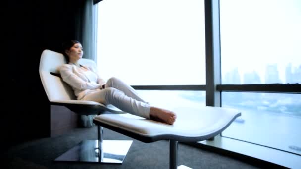 Mujer de negocios relajante en silla moderna
 - Metraje, vídeo