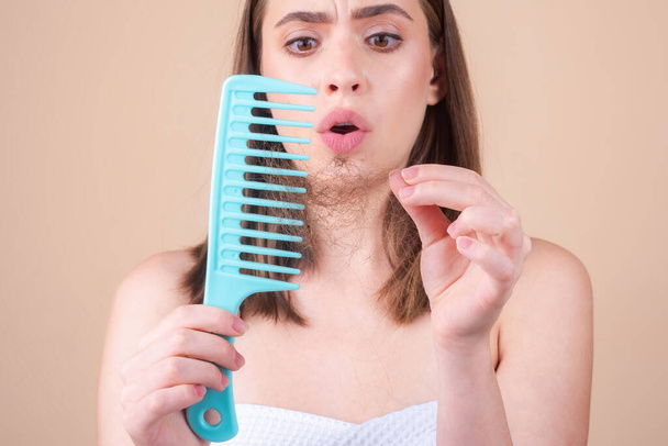 Woman with hair problem. Woman is looking shocked to her lost hair. Head bald and hair treatment concept - Foto, imagen