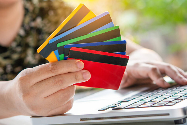 Kredi kartı ödemesi. Kadın elleri kredi kartı tutuyor ve dizüstü bilgisayar kullanıyor. İnternetten alışveriş - Fotoğraf, Görsel