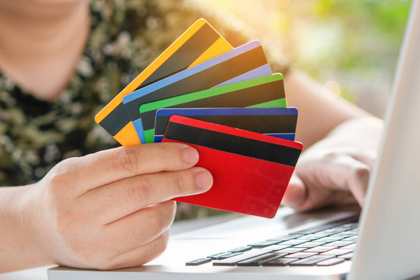クレジットカード決済。女性の手はクレジットカードを保持し、ラップトップを使用して。オンラインショッピング - 写真・画像