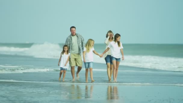 Vanhemmat tyttäriensä kanssa kävelemässä rannalla
 - Materiaali, video