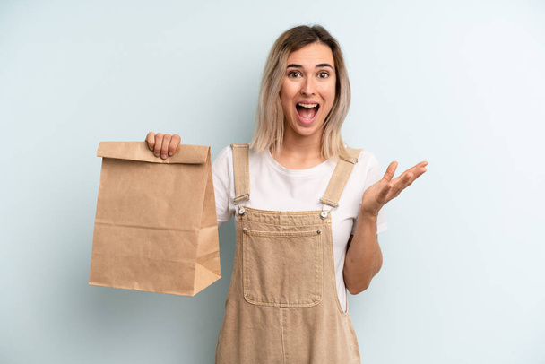 blonde woman feeling happy, surprised realizing a solution or idea. take away delivery concept - Photo, image