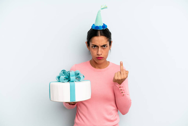 hispanic woman feeling angry, annoyed, rebellious and aggressive. birthday cake concept - Фото, зображення
