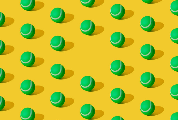 Arranged of green rubber tennis balls on yellow pastel background. Copy space. - Foto, immagini