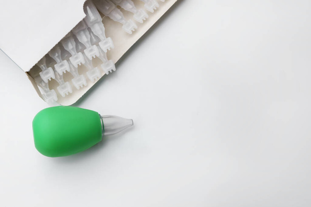 Package with single dose ampoules of sterile isotonic sea water solution and nasal aspirator on white background, top view. Space for text - Foto, immagini