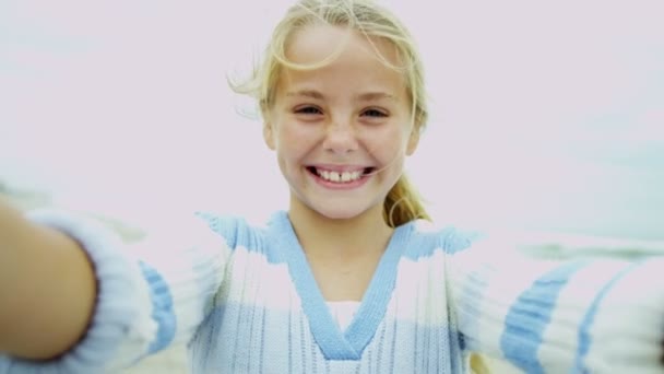 Tyttö rannalla hymyilee kameralle
 - Materiaali, video