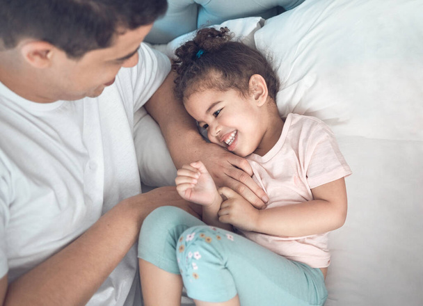 Shot of a dad and daughter bonding in bed together. - Photo, Image