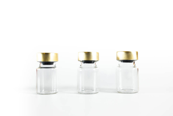 Tres pequeños frascos de vidrio vacíos sobre un fondo blanco. Frascos. Foto de alta calidad - Foto, Imagen