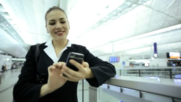 Бизнесвумен в аэропорту с помощью смартфона
 - Кадры, видео