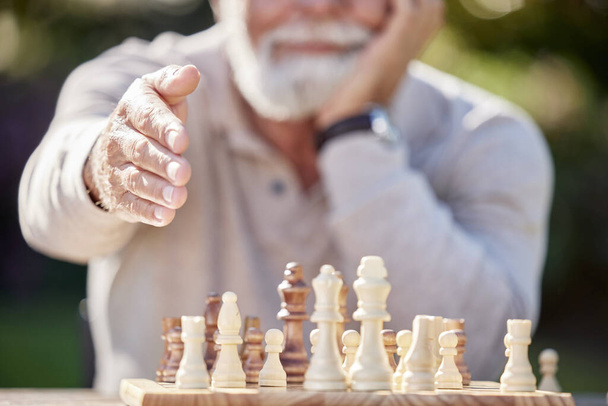 Shot of a senior man reaching to shake hands while playing a game of chess outside. - Photo, image