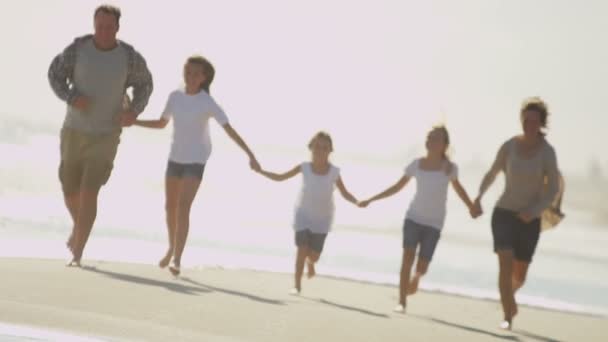 Familia caminando descalza a lo largo de la playa
 - Imágenes, Vídeo