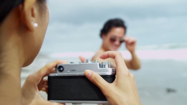 Casal na praia usando câmera
 - Filmagem, Vídeo