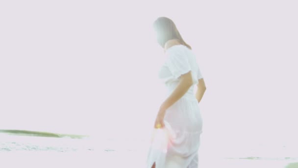 Nő a fehér sundress óceán mellett - Felvétel, videó