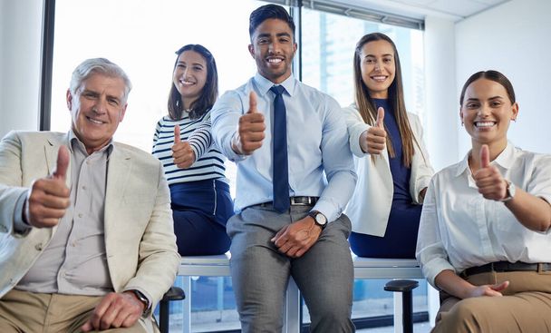 Фотография группы бизнесменов, показывающих большие пальцы в офисе. - Фото, изображение