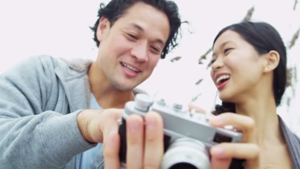 Casal em férias na praia usando a câmera
 - Filmagem, Vídeo