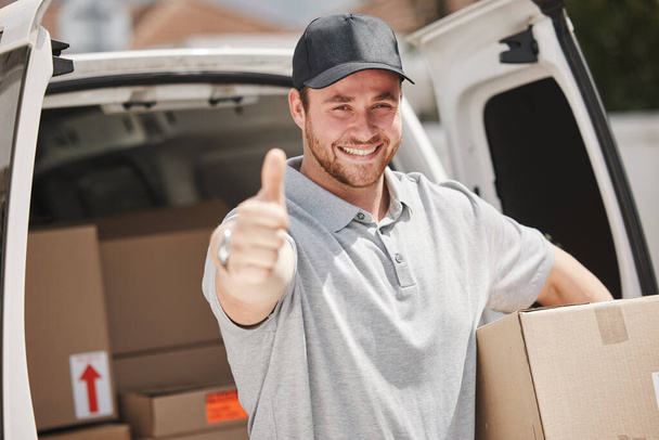 Cropped portrait of a handsome young delivery man giving thumbs up while out making deliveries. - Foto, Imagen