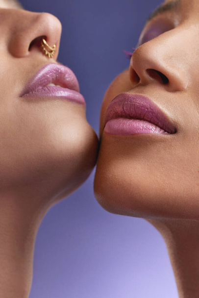 Обрезанный снимок двух молодых женщин с фиолетовым макияжем. - Фото, изображение