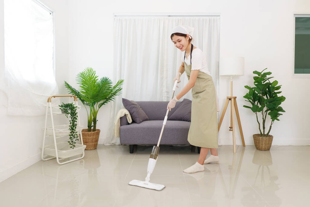 Lifestyle in living room concept, Young Asian woman cleaning the floor with vacuum cleaner. - Foto, afbeelding